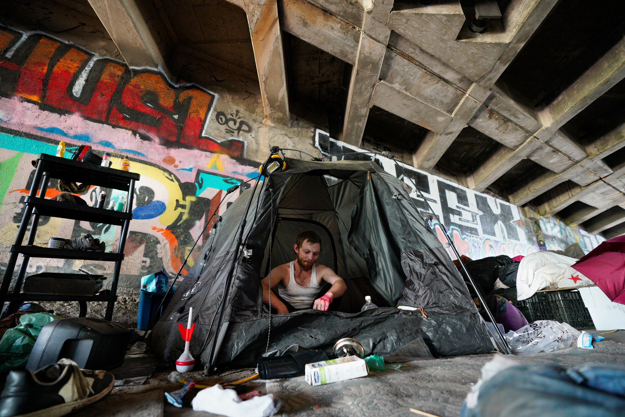 Elijah Biddle,27 sits in his tent at an encampment located in a tunnel under a freeway in San Diego. Biddle, who has been homeless for the past 11 years, says he has plans but loses the motivation from constant life setbacks. (Nelvin C. Cepeda / The San Diego Union-Tribune)
